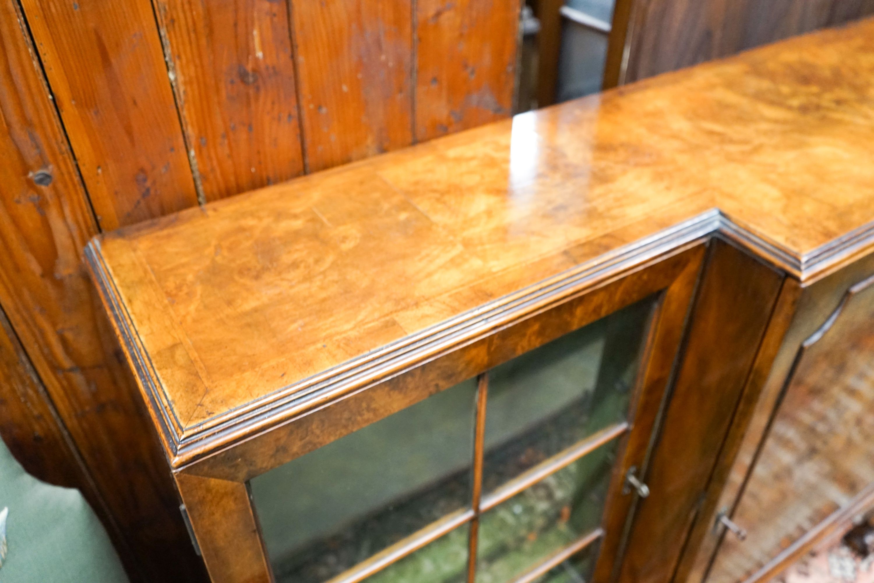 A Queen Anne revival figured walnut breakfront bookcase